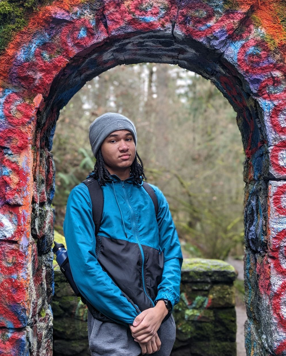 A picture of Isaiah Tsikayi under a colorful outdoor arch